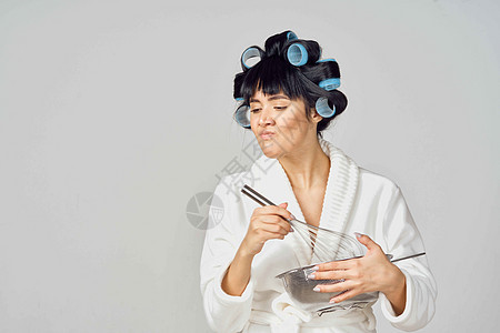 穿着白袍 头头上有卷卷卷头发的女子在厨房做功课烹饪衣服工人唱歌工具女性女孩手套橡皮蓝色图片