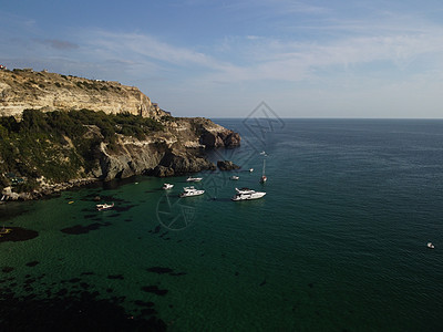 海景空中全景与水晶般清澈的蔚蓝大海和岩石海岸 在岩石背景下的美丽泻湖中的游艇 夏季旅行和度假的理想目的地的概念荒野悬崖巡航天线假图片