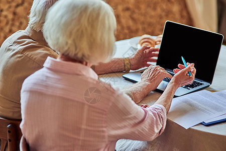 在家使用计算机的年长丈夫和妻子男性老年文档女士屏幕账单房子家庭女性预算图片
