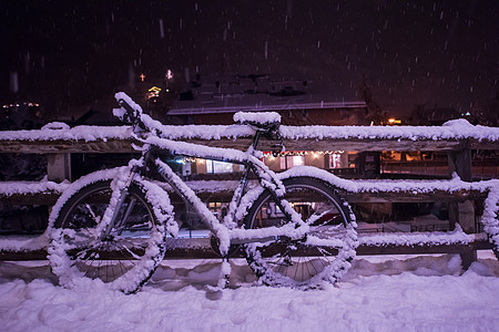 雪雪覆盖的停泊自行车座位季节城市暴风雪旅行街道降雪运输车轮气候图片