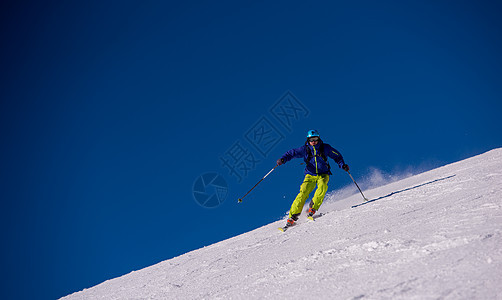 滑雪者在下坡时玩得开心速度天空运动冻结男人空气季节行动娱乐滑雪图片