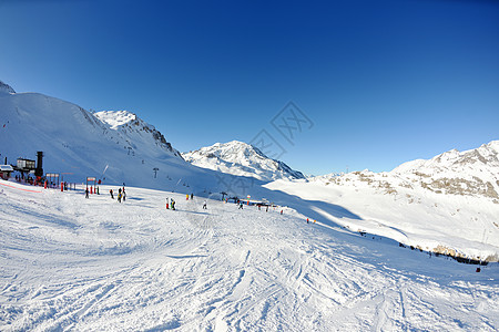 冬天下雪的高山高山蓝色太阳滑雪季节岩石爬坡运动假期顶峰首脑图片