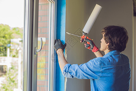 穿蓝衬衫的男人安装窗户的装置男性技术办公室塑料组装工人玻璃建造维修房子图片