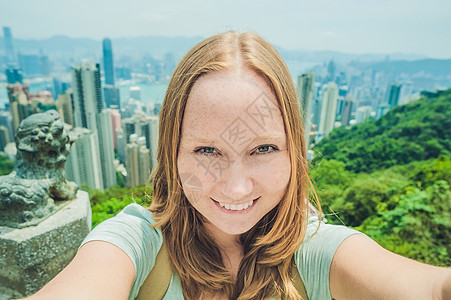 在中国香港拍摄胜利港照片的年轻女青年 女士建筑天空相机手机女孩顶峰天际摄影商业地标背景图片