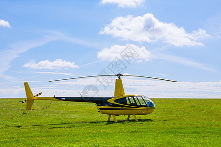 现代小型轻型直升机在草地上对准蓝天图片