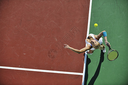 年轻妇女户外打网球比赛成人娱乐游戏锻炼运动员橙子运动活动球拍图片