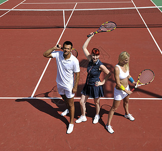 快乐的年轻夫妇在户外玩网球游戏运动员橙子比赛爱好球拍竞赛法庭朋友男性乐趣图片