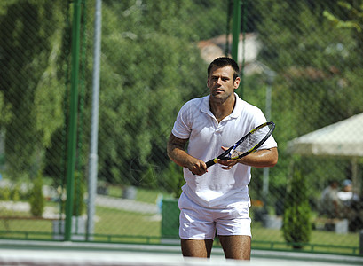 青年男子在户外打网球娱乐闲暇运动锻炼游戏玩家活动男性球拍成人图片