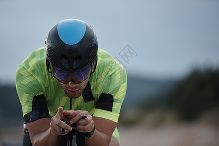 骑自行车的三重运动员赛车手头盔轮子男性活力耐力运动行动竞赛训练图片