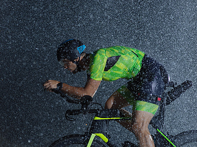 下雨之夜骑自行车的三重运动员活力钢铁侠头盔训练耐力运动竞赛铁人天气速度图片