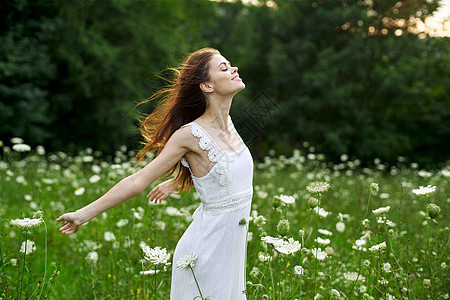 欢乐的户外妇女开着自由的夏月性花朵裙子女性草地女孩太阳阳光皮肤公园微笑金发图片