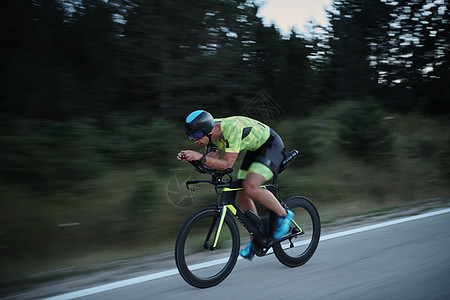 夜间骑自行车的三重运动员耐力男性训练运动头盔健康轮子活力钢铁侠导航图片