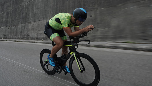 早上训练时骑自行车的三重运动员速度赛车手男性男人耐力钢铁侠竞赛健康运动行动图片