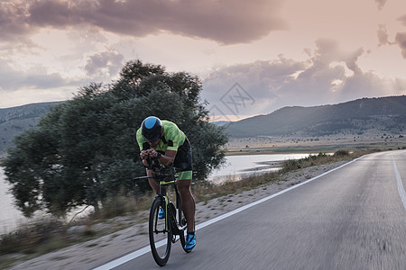 骑自行车的三重运动员耐力铁人速度男人行动活力轮子头盔训练竞赛图片