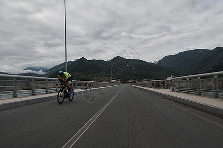 早上训练时骑自行车的三重运动员速度头盔活力导航行动运动男性竞赛耐力赛车手图片
