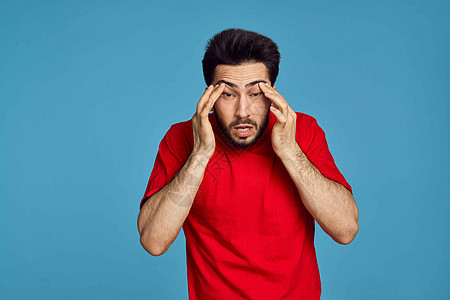 男性穿红色T恤男子的健康问题 情绪症状蓝色背景插头痛苦商业耳炎耳痛男人衬衫成人脖子偏头痛图片