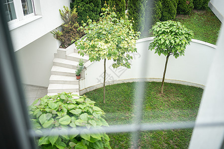 绿色花园后院的美丽窗口视图阳台草地椅子楼梯玻璃叶子房子村庄住宅别墅图片