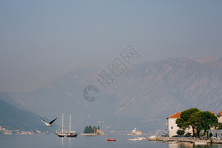 海底海岸外的帆船 其背景是山地和黑山图片