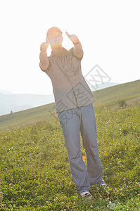 男人在户外跳跃草地太阳身体胜利幸福商业蓝色天空自由微笑图片