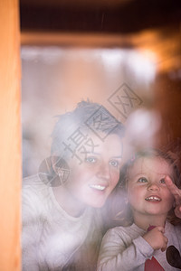 年轻母亲和可爱的小女儿在窗边玩耍思维窗台玩具家庭童年孩子妈妈女孩房子安全图片