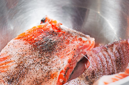 两片熟熟的鲑鱼 躺在圆光闪闪的盘子里图片