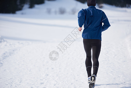 在森林积雪上慢跑男人锻炼天气踪迹跑步运动活动运动员晴天公园图片