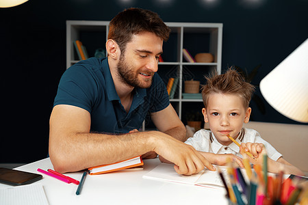 父亲帮助小儿子做功课的功课家庭作业写作成人男生学校房子笔记桌子男人家庭图片