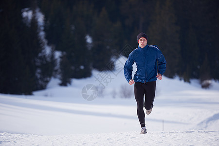 在森林积雪上慢跑耀斑男人晴天训练成人公园运动乐趣耐力活动图片