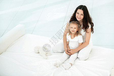 母亲和女儿在客厅的沙发上玩婴儿女性拥抱感情妈妈父母成人女士卧室压痛图片