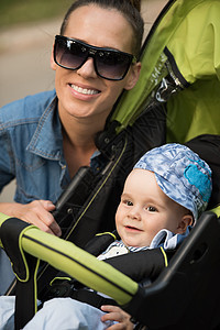 公园中的母亲和婴儿越野车太阳镜成人乐趣婴儿车儿子女士幸福男生童年图片