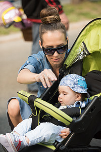 公园中的母亲和婴儿太阳镜男生女孩婴儿车成人儿子幸福女性母性孩子图片