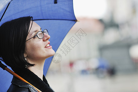 妇女带着雨伞在街上流浪季节天气蓝色城市雨量购物夹克下雨街道风暴图片