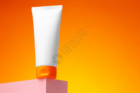 橙色背景的白白化妆品空容器护理奶油包装产品管子空白洗剂皮肤卫生瓶子图片