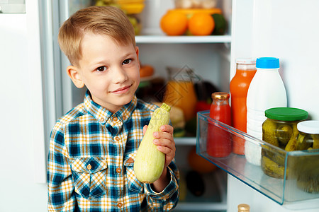 小男孩站在开着的冰箱前 选择食物水果保健童年小吃卫生男生营养饥饿男性蔬菜图片