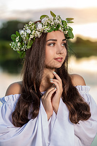 穿着白色连衣裙的女人在水中 头戴花圈的艺术女人在河中 她头上的花环 斯拉夫传统和异教魅力女性精神女子花冠魔法女士礼服水仙女火车图片