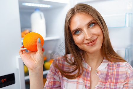 一位年轻金发女子从冰箱里拿食物的肖像饮食减肥损失午餐主妇女性水果早餐家庭杂货店图片