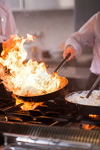 厨师在食物上做烧烤美食燃烧行动烤箱用餐午餐盘子平底锅厨房火焰图片