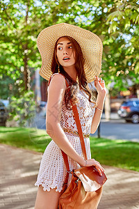 阳光明媚的生活方式时尚肖像年轻时尚时髦女人走在街上 穿着时髦的衣服 草帽 背着背包旅行晴天微笑帽子女性太阳成人潮人女孩头发街道图片