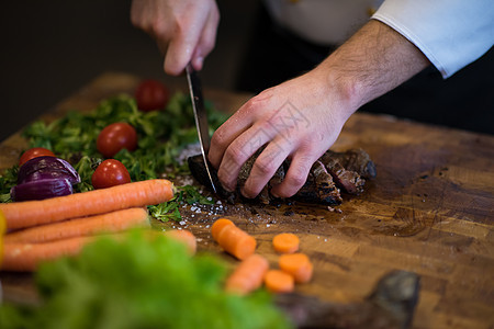 把准备牛肉牛排的厨师双手拉紧精加工牛扒工作美食蔬菜职业食谱男性餐厅酒店图片