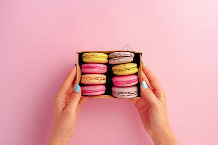 女人手握着装满多彩的红毛松饼干的盒子粉色甜点蛋糕杏仁礼物食物生日饼干糕点美食图片