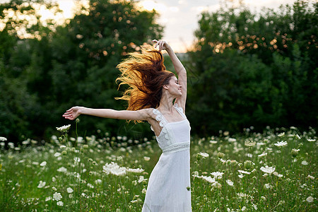 穿着白色衣服的女子 假扮成大自然的夏季舞蹈阳光皮肤公园自由女孩微笑草地享受帽子裙子图片