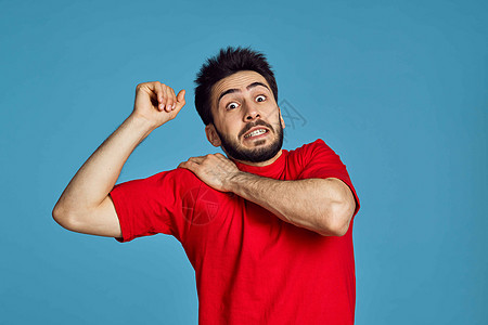 男性穿红色T恤男子的健康问题 情绪症状蓝色背景治疗伤害背痛肩膀紧张解剖学手臂关节炎男人肌肉图片