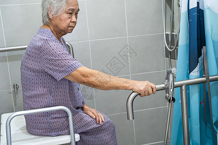 亚洲老年或老年老妇人病人在护理医院病房使用厕所浴室手柄安全 健康强大的医疗理念座位减值苗圃淋浴洗澡照片金属合金酒吧扶手图片
