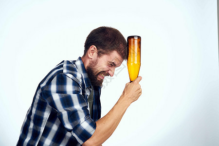 一个穿着格子衬衫的男人 啤酒酒精情调 欢乐的光背景饮料男性挫折手臂成人瓶子宿醉休闲装压力玻璃图片