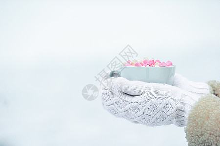 女性手用白色和粉色棉花糖握着白咖啡杯制品杯子咖啡可可陶瓷季节手套饮料味道牛奶图片