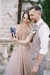 新娘和新郎用智能手机拍一个带戒指的自拍图片