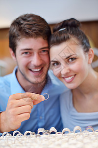 珠宝店一对快乐的年轻夫妻购物销售首饰展示金子女士戒指男朋友零售商业图片