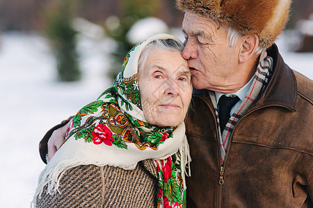 年长夫妇的画像 老人亲吻他的妻子很有分量 老夫妇在冬天的时候在公园散步 幸福的家庭 金婚微笑退休成人婚礼女性乐趣女士皱纹长老皮肤图片