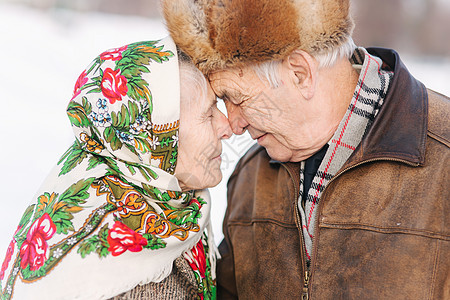 愉快的年长夫妇画象 老妇人重重地亲吻她的丈夫 老夫妇在冬天的时候在公园散步 幸福的家庭 金婚女士长老皮肤成人皱纹微笑男人老年人季图片