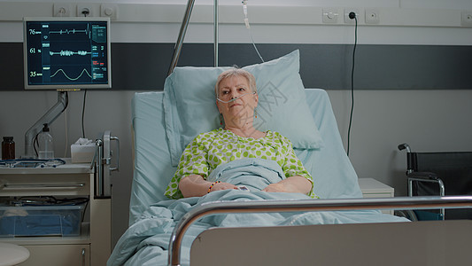 高级病人躺在医院病房床铺的长者肖像图片